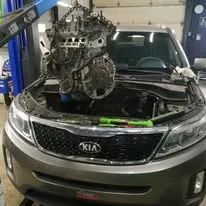 Moteur suspendu au-dessus du compartiment moteur d’un véhicule dans l’atelier